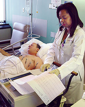 Foto de una týcnico realizando un electrocardiograma.